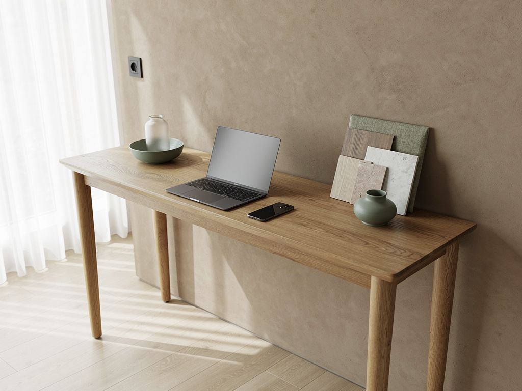 A calm studio entrance with an oak console, a laptop, a phone and a stack of material samples, nobody in focus.